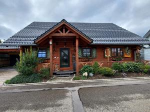 een houten huis met een zwart dak bij Blockhaus im Süden Deutschlands in Höchenschwand