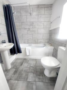 La salle de bains est pourvue d'une baignoire, de toilettes et d'un lavabo. dans l'établissement The Black Lion Royal Hotel, à Lampeter