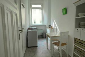 a white kitchen with a table and a refrigerator at Ferienwohnung Berlin Tiergarten in Berlin