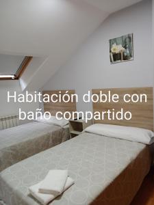 1 dormitorio con 1 cama con 2 toallas en Pension Ameneiral, en O Pedrouzo