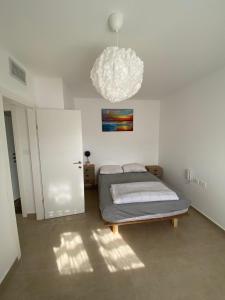 a bedroom with a bed and a chandelier at Nahal Beer sheva נחל באר שבע in Beer Sheva
