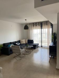 a living room with a blue couch and a table at Nahal Beer sheva נחל באר שבע in Beer Sheva