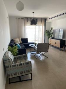 a living room with a couch and a table and chairs at Nahal Beer sheva נחל באר שבע in Beer Sheva