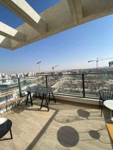 a balcony with tables and chairs and a view of a city at Nahal Beer sheva נחל באר שבע in Beer Sheva