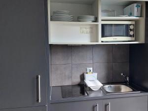 Una cocina con gabinetes blancos y un fregadero. en The Lodge at Ribasol, en Arinsal