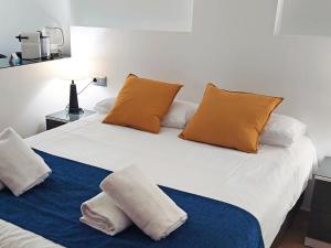 a white bed with two pillows on top of it at The Lodge at Ribasol in Arinsal