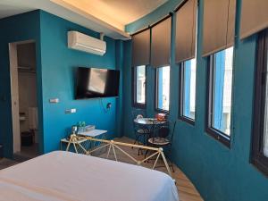 a room with a bed and a blue wall at Fangliao Chun Lai Homestay in Fangliao