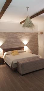 1 dormitorio con 1 cama grande y pared de ladrillo en Casa Rosamari - su Lago di Posta Fibreno, Appartamento con camino, en Posta Fibreno