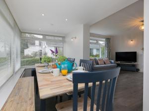 a dining room and living room with a table and chairs at The Pines in St Ives