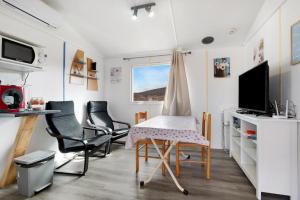 uma sala de estar com uma mesa e cadeiras e uma televisão em COUNTRY HOME em La Asomada