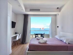 una camera con letto e vista sull'oceano di Boutique Lungomare a Porto Torres
