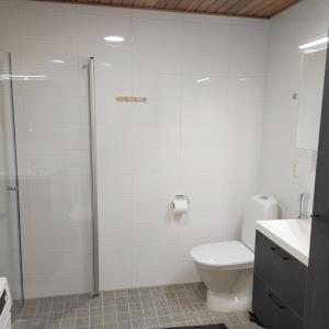 La salle de bains blanche est pourvue d'une douche et de toilettes. dans l'établissement Ihana uusi huoneisto, hyvällä sijainnilla, à Seinäjoki