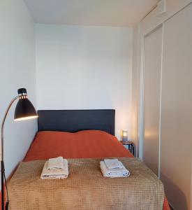 a bedroom with a red bed with two towels on it at Ihana uusi huoneisto, hyvällä sijainnilla in Seinäjoki