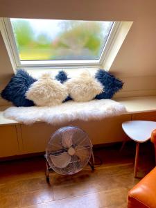 a window seat with stuffed teddy bears and a fan at Private Loft Country Hideaway in Shifnal