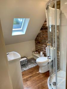 a bathroom with a toilet and a sink and a window at Private Loft Country Hideaway in Shifnal