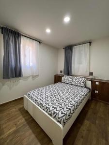 Un dormitorio con una cama y dos ventanas. en Portalegre, en Madrid