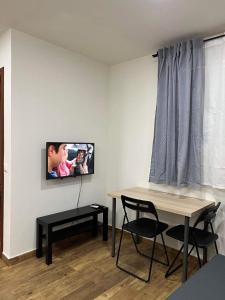 a living room with a table and a tv on the wall at Portalegre in Madrid