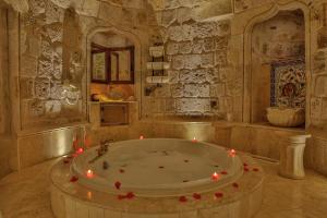 a large bathroom with a tub with candles in it at Şah Saray Cave Suites Halal Hotel in Göreme