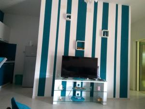 a living room with a tv and a striped wall at Apartment Tara in Sumartin