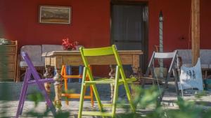 Quiet little country house with breathtaking view في Áyios Síllas: مجموعة من الكراسي الملونة بجوار طاولة