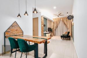a dining room with a wooden table and green chairs at Legasi Kampung Baru Guesthouse in Kuala Lumpur