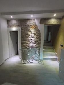 une pièce vide avec un mur en pierre et des escaliers dans l'établissement Home sweet home, à Calangianus