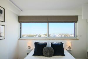 een slaapkamer met een bed en een groot raam bij Phaedrus Living: Luxury Suite Nicosia 501 in Nicosia