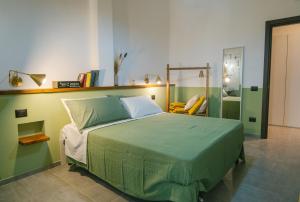 - une chambre avec un lit vert et un miroir dans l'établissement Maga Mirò - Guest House, à Salerne