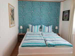 a bedroom with a large bed with a blue wall at Haus zur Traube in Klotten