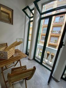 サレルノにあるMaga Mirò - Guest Houseのテーブルと椅子、窓が備わる客室です。