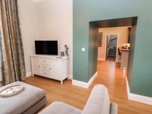 a living room with a couch and a tv at 1 Claire House Way in Barnard Castle