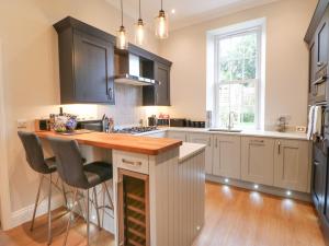 a kitchen with black cabinets and a wooden counter top at 1 Claire House Way in Barnard Castle