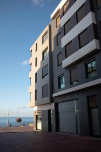 un edificio con el océano en el fondo en Gloriamar Las Canteras en Las Palmas de Gran Canaria