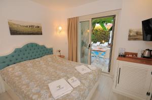 a bedroom with a bed with two towels on it at Giritlim Otel in Çeşme +21 photos