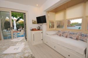 a bedroom with a bed and a tv and a window at Giritlim Otel in Çeşme