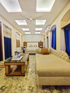 ein Wohnzimmer mit einem Sofa und einem Tisch in der Unterkunft The Reverent Ganga in Haridwar