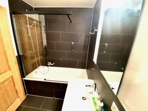 a bathroom with a tub and a sink and a mirror at Chesery 1 in Morgins