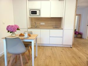 a kitchen with a table and a chair and a microwave at Apartamentos Pico de Langre in Langre