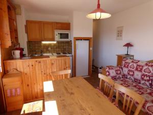 a kitchen and a living room with a couch and a table at Appartement Le Grand-Bornand, 2 pièces, 6 personnes - FR-1-458-108 in Le Grand-Bornand