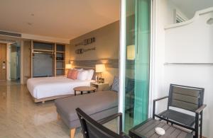 アオナンビーチにあるCentara Ao Nang Beach Resort & Spa Krabi - SHA Plusのベッドと椅子付きのホテルルーム