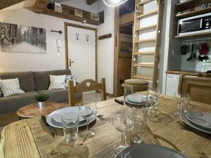 a dining room table with wine glasses on top of it at Appartement Praz-sur-Arly, 1 pièce, 6 personnes - FR-1-603-47 in Praz-sur-Arly