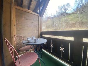 a table and chairs on a balcony with a window at Appartement Praz-sur-Arly, 1 pièce, 6 personnes - FR-1-603-47 in Praz-sur-Arly