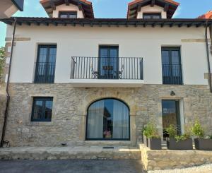 a house with a balcony and windows at Apartamentos Pico de Langre in Langre