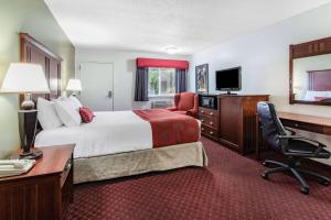 a hotel room with a bed and a desk and chair at Baymont by Wyndham Bozeman in Bozeman