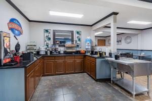 a large kitchen with wooden cabinets and a sink at Baymont by Wyndham Bozeman in Bozeman