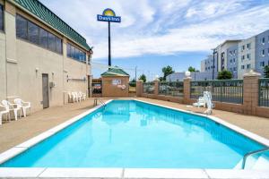 a pool at a hotel with chairs and a building at Days Inn by Wyndham Clarksville North EXIT 4 in Clarksville