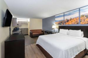 a hotel room with a bed and a kitchen at Days Inn by Wyndham Clarksville North EXIT 4 in Clarksville