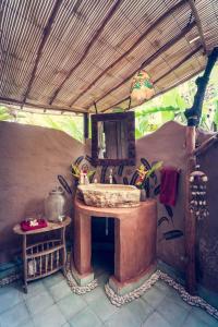 W pokoju na świeżym powietrzu znajduje się łazienka z umywalką. w obiekcie Dragonfly Village w mieście Ubud