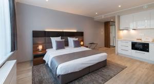 um quarto com uma cama grande e uma cozinha em Smartflats - Midi 33 em Bruxelas