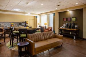 a waiting room with a couch and a bar at Baymont by Wyndham Columbus GA in Columbus